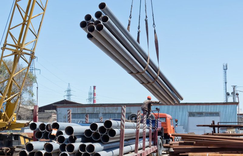 Why Proximity Matters When Selecting Steel Tube Manufacturers 1 exterior photo of a steel manufacturers facility with trucks loading tubing