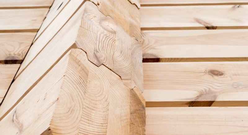 Close-up of glulam wood beams showing layered grain and joinery.