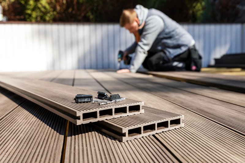 Hidden clip fastener securing composite deck boards.