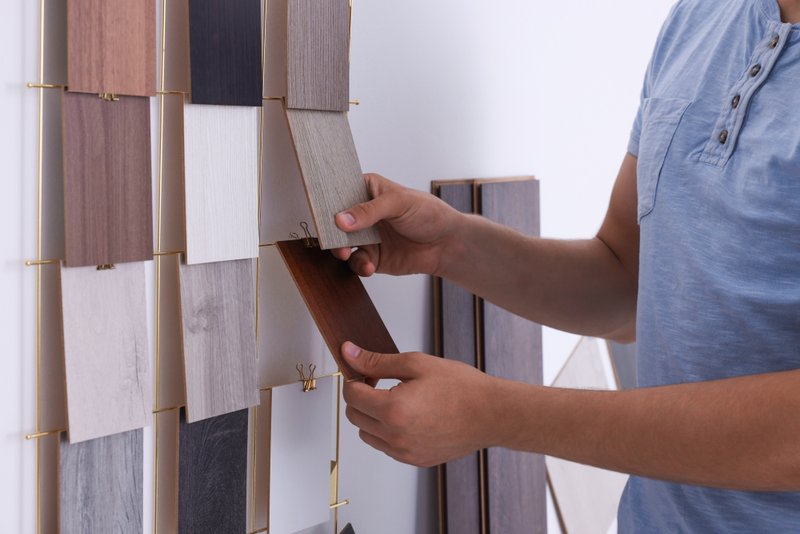 Homeowner comparing composite decking color and material options.