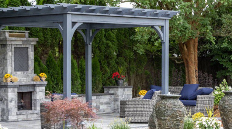 Backyard pergola built with structural beams over an outdoor seating area.