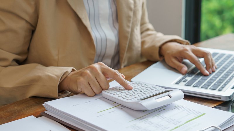 A close up of volunteer HOA treasurer reviewing community payments and association financial records