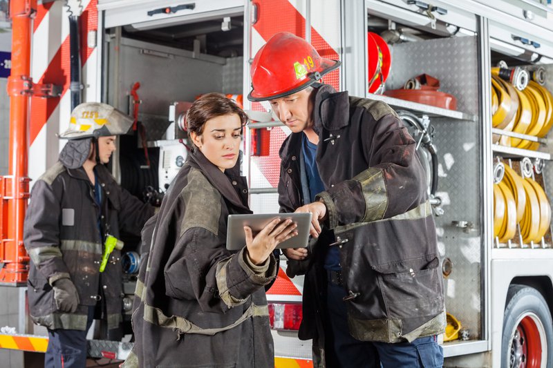 Firefighters referring to a mobile command board.