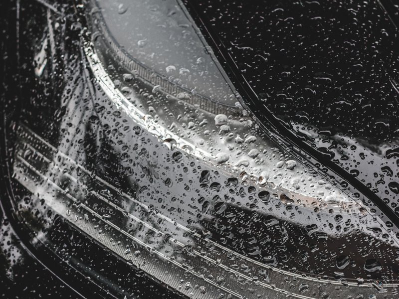 headlights still wet from a session in a car wash station