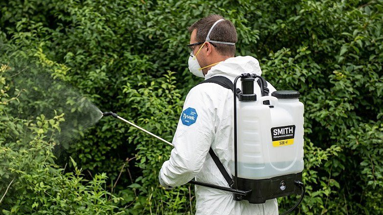 a professional pest controller using the right pump sprayer for his profession