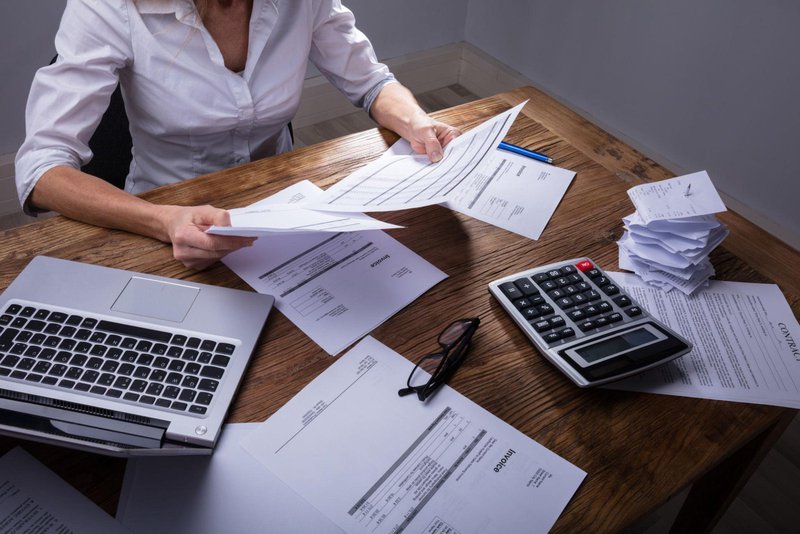 Business owner organizing invoices and payment documents to improve cash flow.