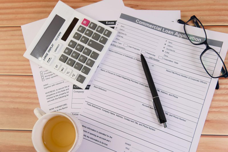 Business loan application paperwork and financial documents on a desk.
