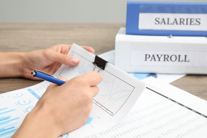 Payroll administrator processing weekly timesheets for workers