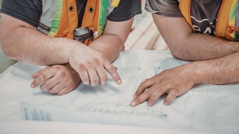 A construction team reviewing architectural drawings to plan compliance for NYC Building Permits.