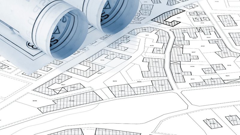 An engineer reviewing building plans on the floor as part of Pre-Construction Due Diligence.