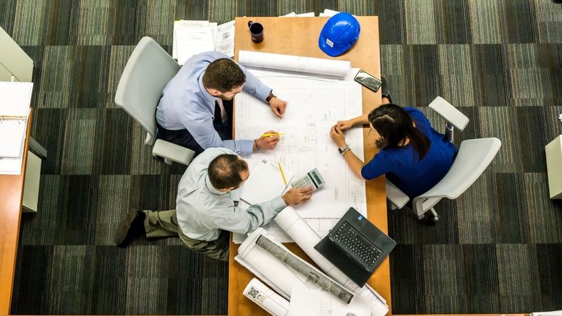 Professionals analyzing project blueprints and calculations for a Zoning Feasibility Study.