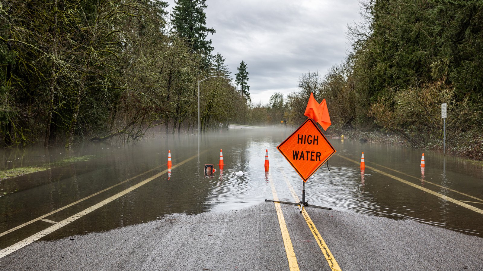 High water warning sign on a flooded road during an exercise that tests an emergency operations plan