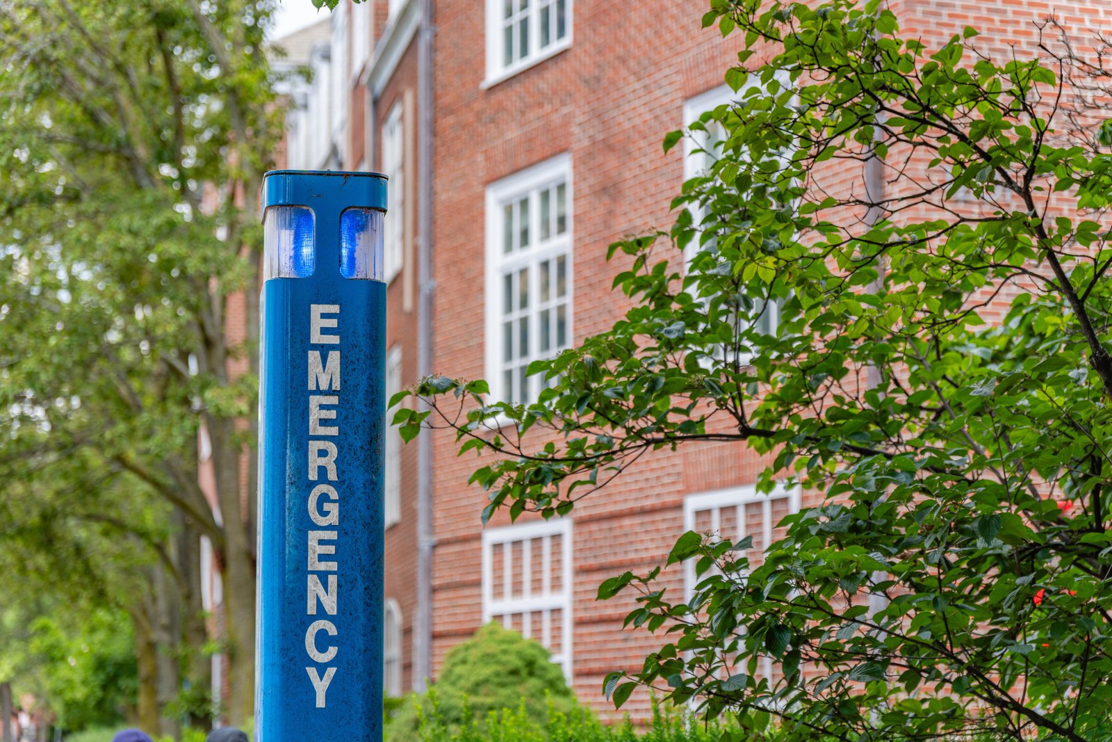 Blue-light emergency call box on a university walkway supporting campus safety and mass notification
