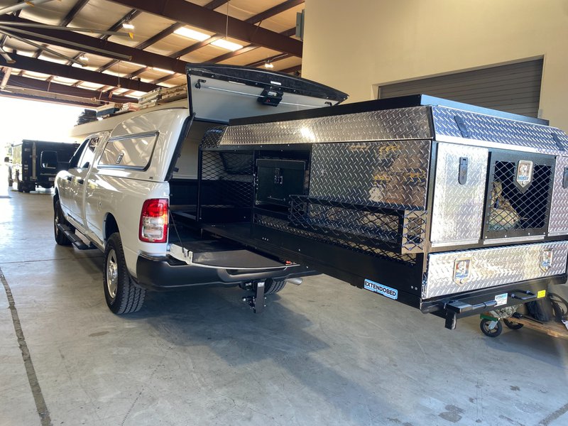 Extendobed slideout system with lockable diamond-plate compartments and mesh containment shelvin
