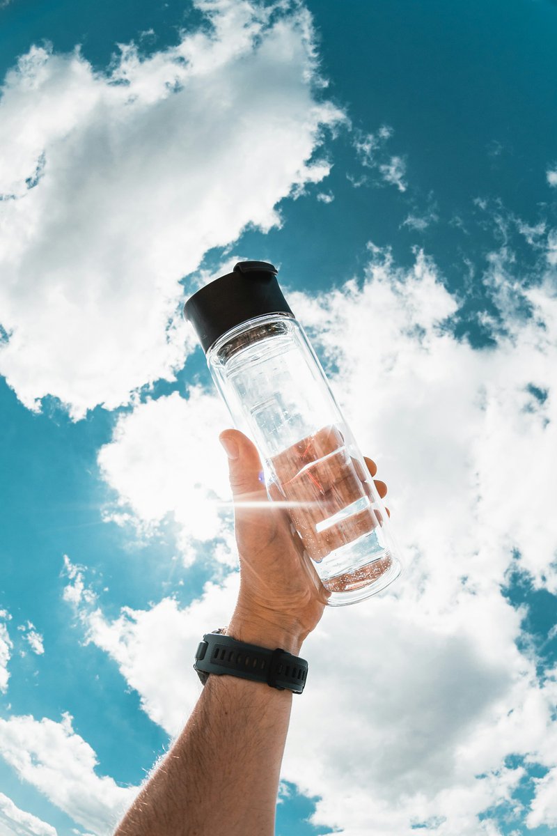 a hand holding a water bottle in front of a blue sky rvezdpcela0 f69f322d1afe39b95ec6219191c6795d 800