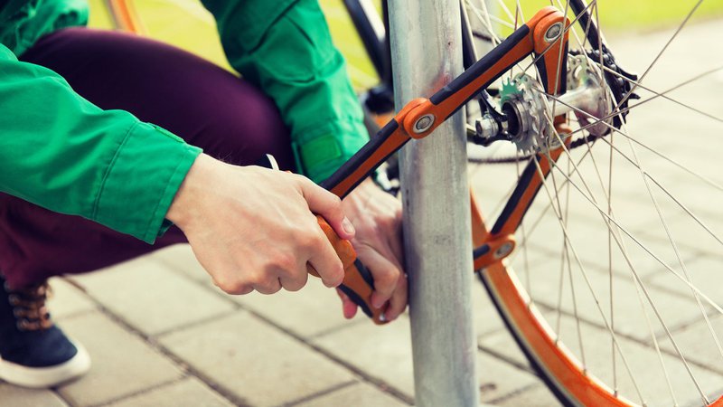 Un cadenas pliable est fixé à un poteau et à la roue arrière d'un vélo.