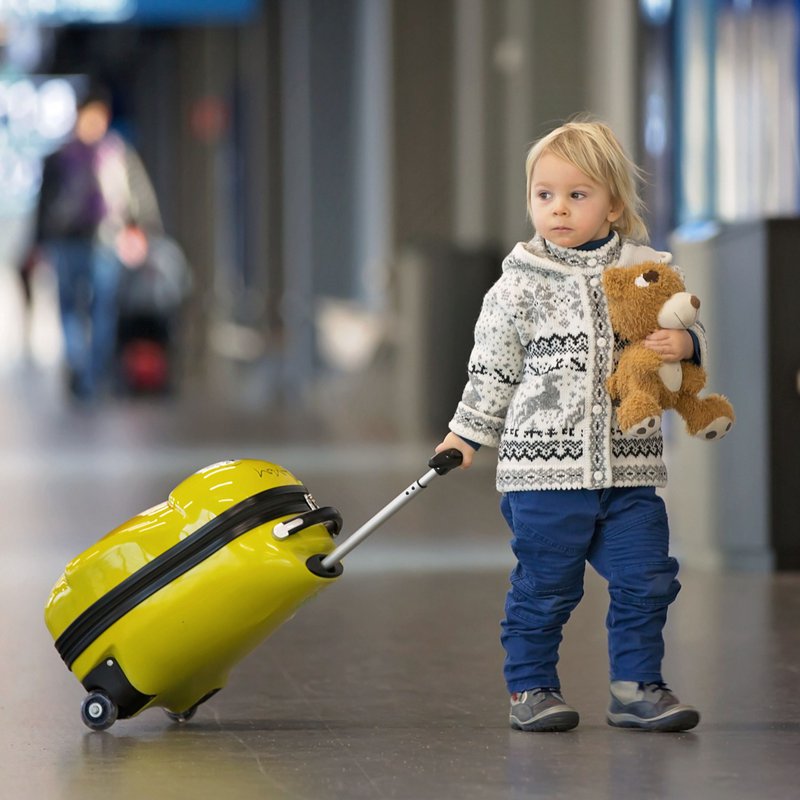 Un petit enfant avec son doudou à l'aéroport
