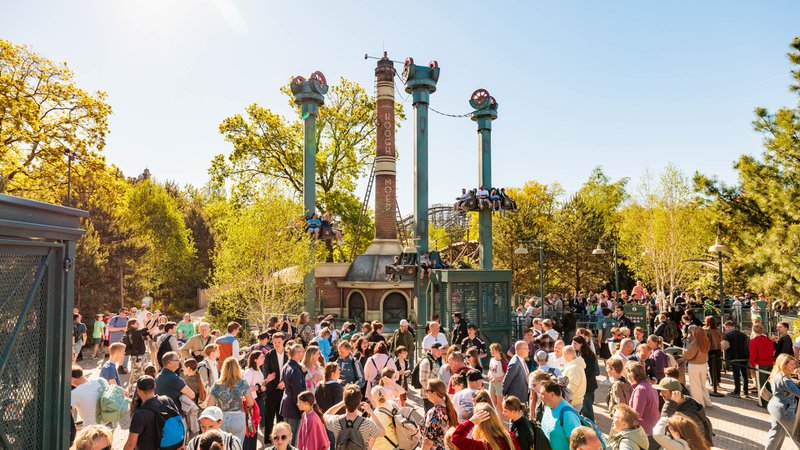 attraction dans un parc d'attractions avec beaucoup de monde au premier plan.