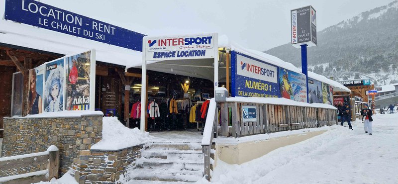 Ski : magasin de matériel de ski dans un paysage hivernal blanc.