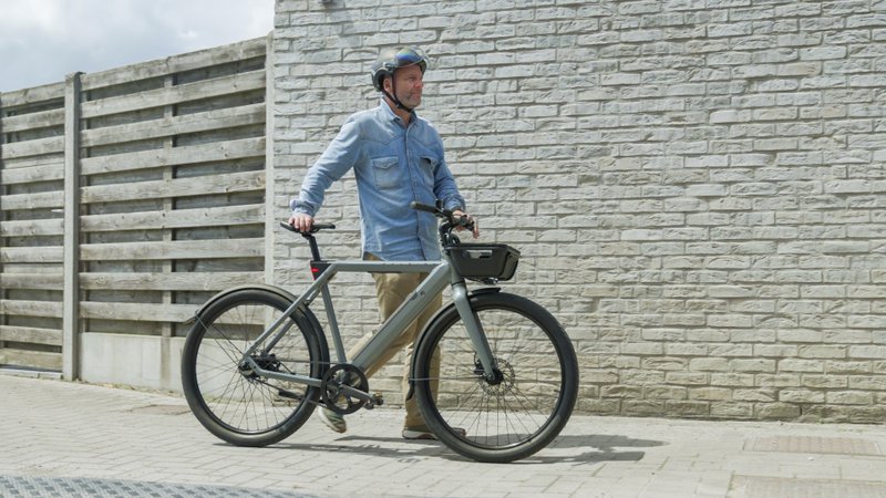 Un homme marche à côté d'un vélo urbain Raleigh One