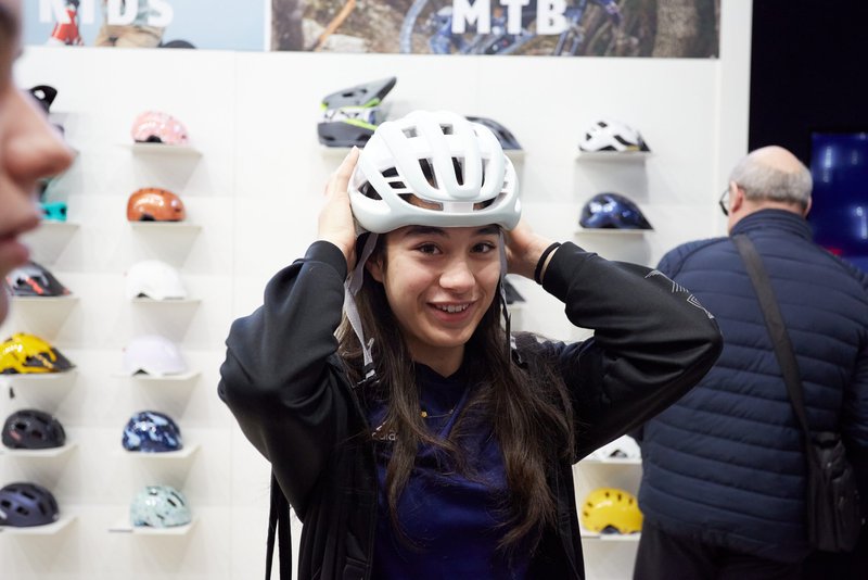 Jongedame met zwart haar probeert een fietshelm