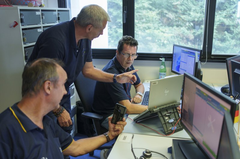 centre de dispatching pour les patrouilleurs, avec trois personnes devant leur écran d'ordinateur.