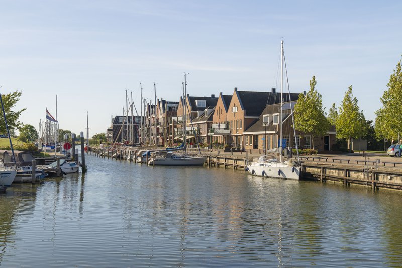Canal avec de petits voiliers amarrés au quai.