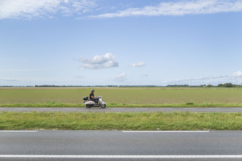 Un scooter solitaire dans le vaste paysage de Goeree-Overflakkee.