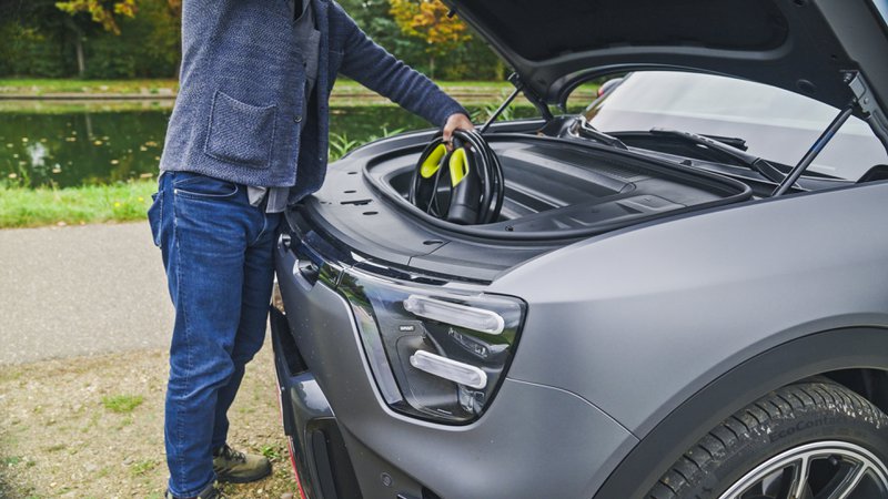 personne en train de déposer un câble de recharge dans le frunk d’une Smart #5.