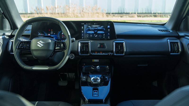 Tableau de bord du Suzuki e-Vitara avec double écran et volant, intérieur du SUV électrique