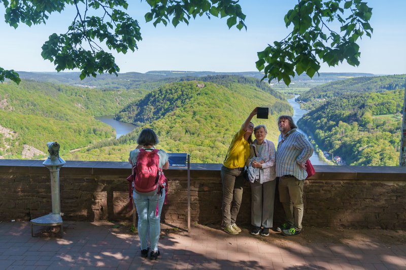 Mensen nemen selfies aan de Saarschleife in Saarland, een meander van een rivier in een bosrijk gebied