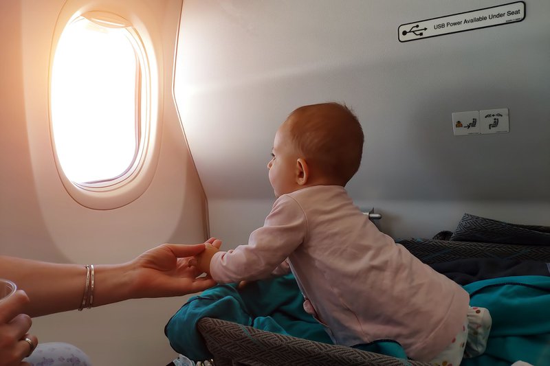 baby in wiegje aan boord van een vliegtuig