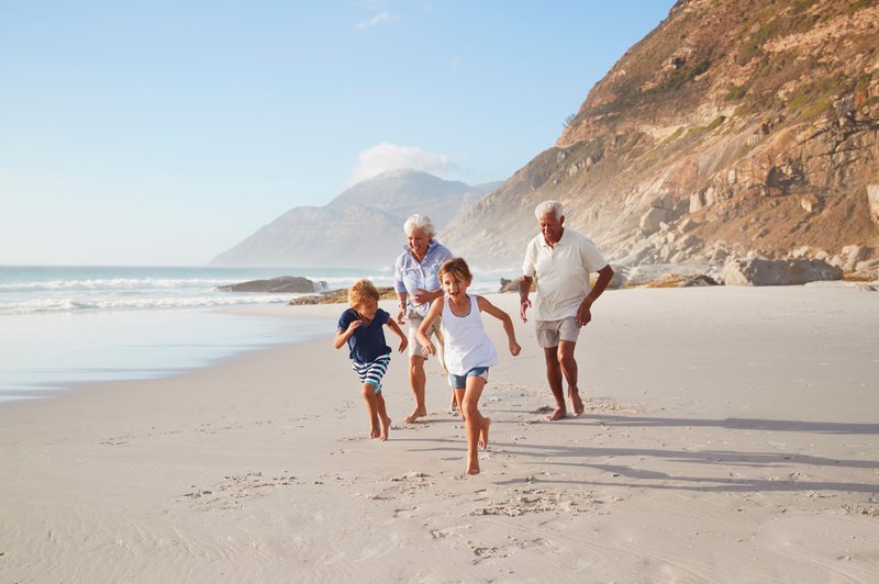 grootouders en kleinkinderen rennen over een strand