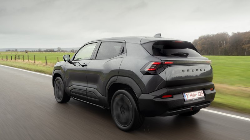 Suzuki e-Vitara vu de l’arrière roulant sur route, SUV électrique compact