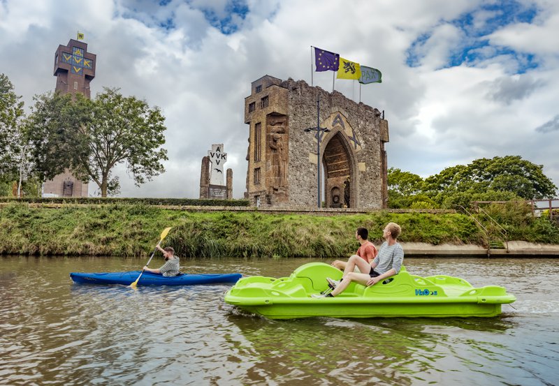 een kano en pedalo op het water met een gebouw en de IJzetroren op de achtergrond - frontsteden