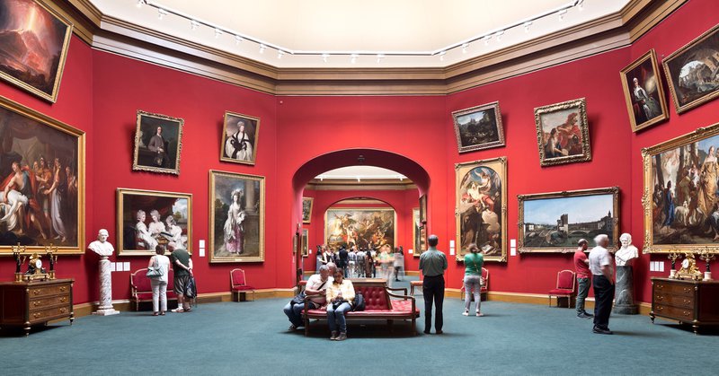 mensen in een museum in Edinburgh, rode muren met talloze schilderijen van grote meesters