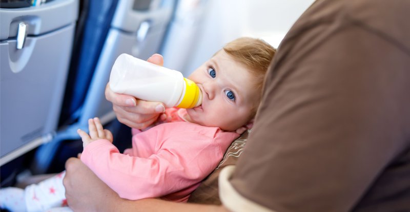 baby krijgt flesje aan boord van een vliegtuig