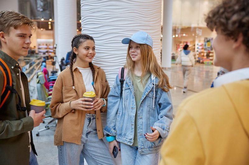 Quatre adolescents discutent entre eux dans un centre commercial