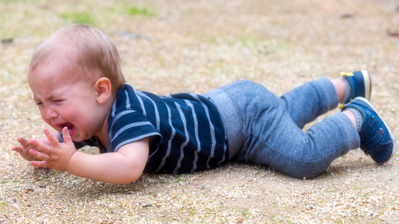 Un enfant épuisé, pleurant par terre.