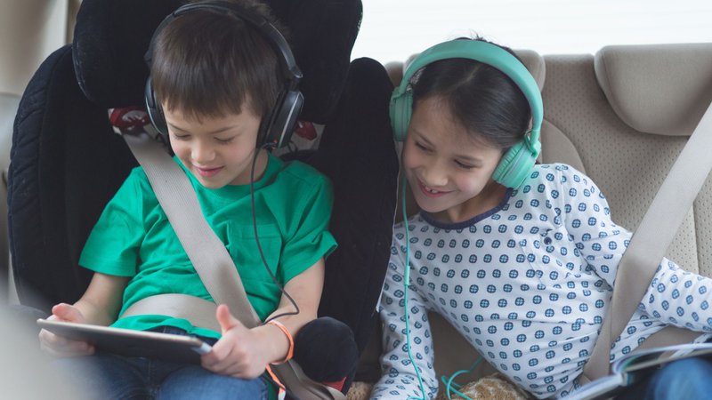twee kinderen op de achterbank van een auto - wagenziek