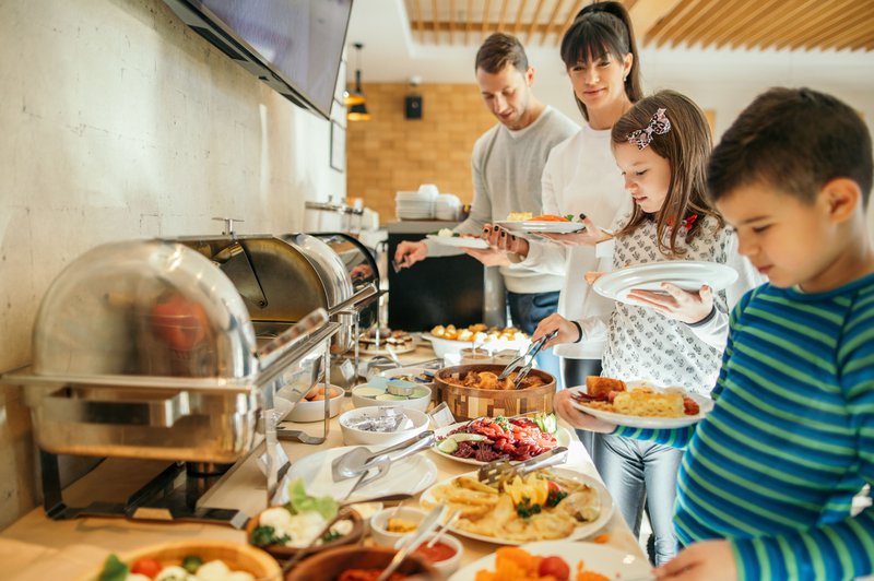 Les enfants et leurs parents se servent au buffet dans un hôtel