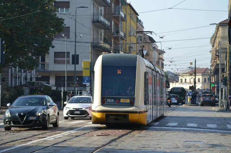 Une rue avec des voitures et un train sur les rails