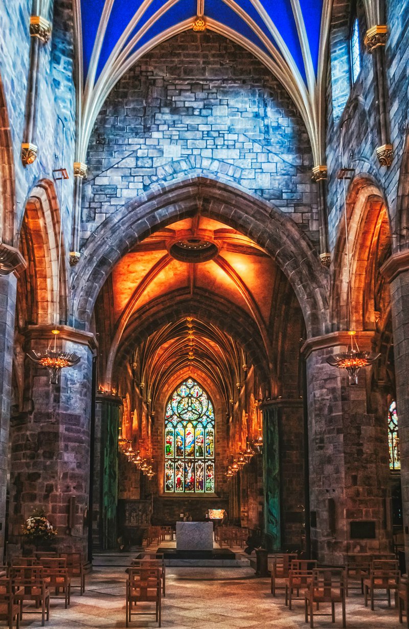 interieur van een kerk met gotische bogen en kleurrijke glasramen