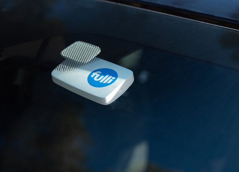 Badge Télépéage Fulli posé à l'intérieur d'un pare-brise.