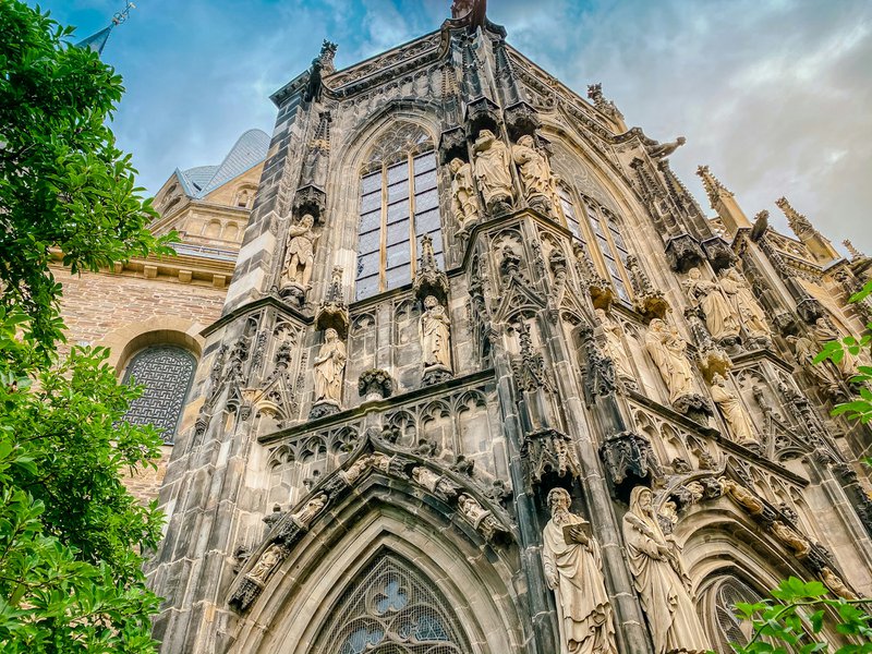 Ancienne façade sombre d'église sur fond de ciel bleu à Aix-la-Chapelle.