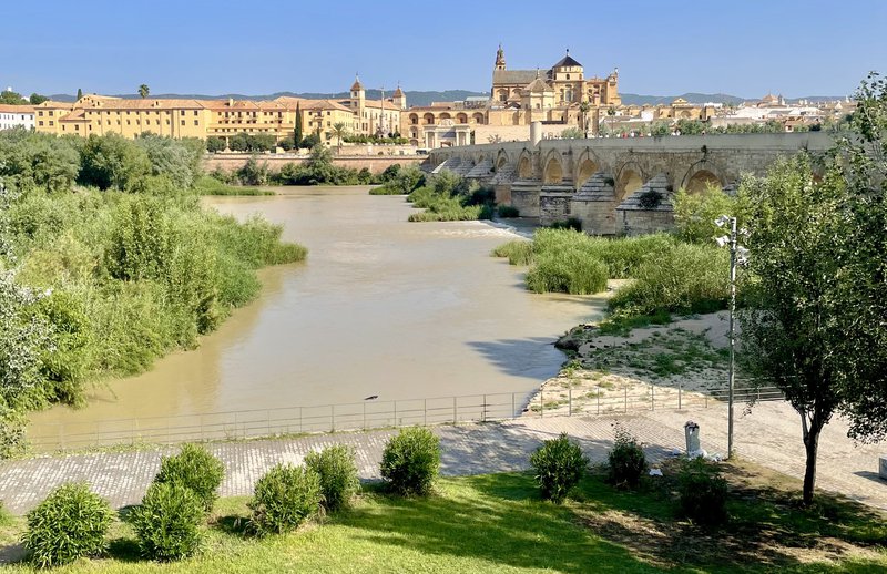 Cruise in Andalusië: brug over een bruine rivier met oude stad op de achtergrond