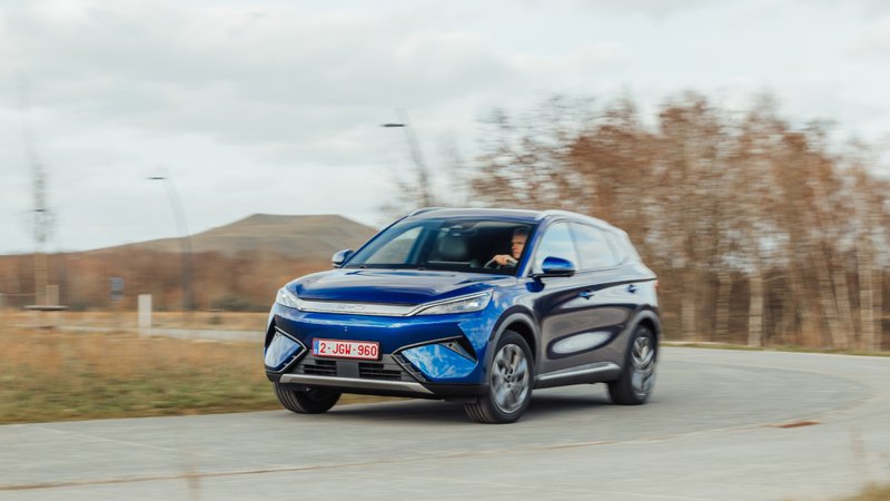 BYD Atto 3 Evo bleu vu de trois quarts avant, en mouvement sur une route dégagée.