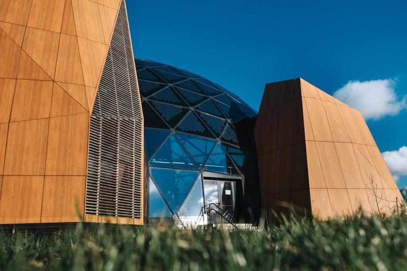 Futuristisch gebouw van glas en hout tegen een blauwe hemel op de Citadel van Namen.