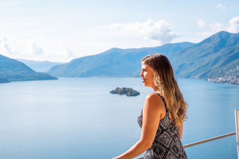 Tessin: jeune femme de profil regardant le lac Majeur.