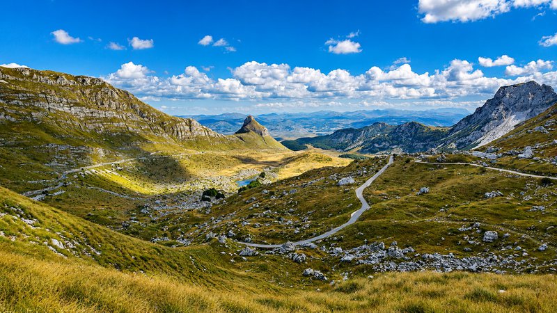 paysage montagneux sauvage, sillonné de routes traversant une nature intacte.